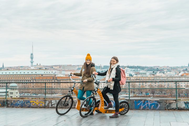 a man and a woman riding on the back of a bicycle