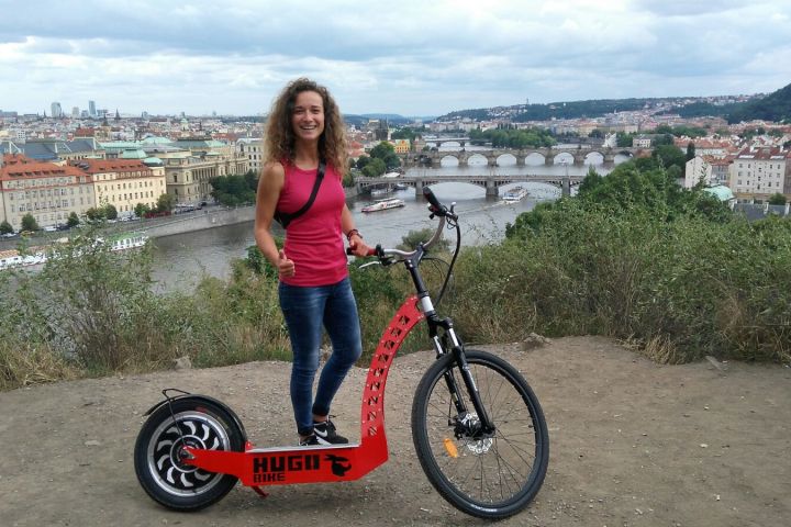 a little girl standing in front of a bicycle