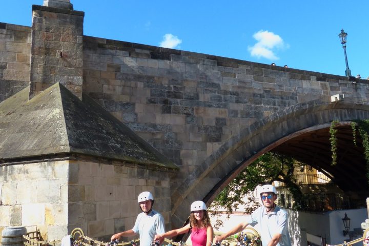 a group of people on a bicycle in front of a building