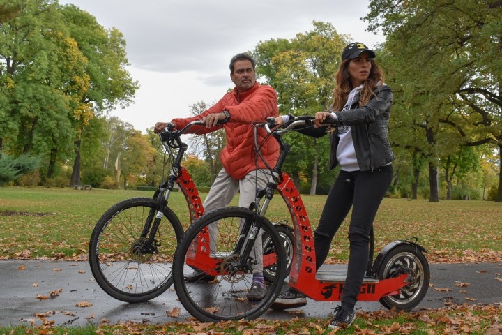 a man and woman riding on the back of a bicycle
