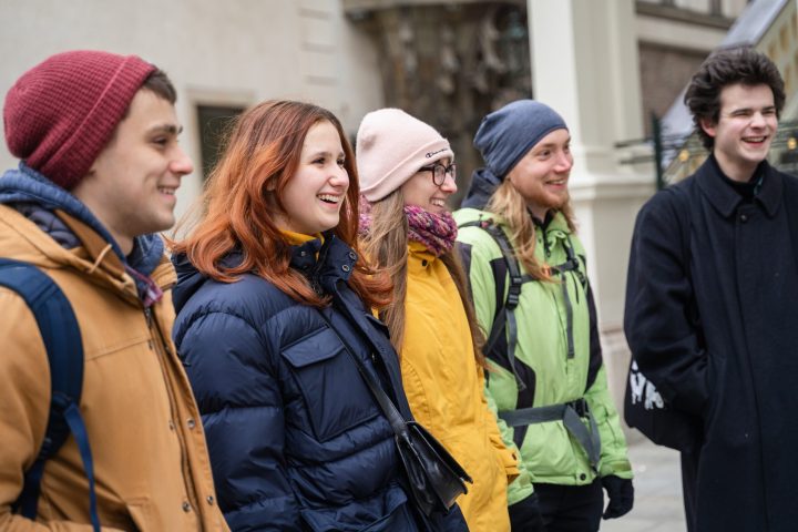 a group of people walking down the street talking on a cell phone
