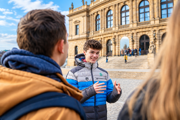Person in colorful jacket conversing outdoors near historical building.