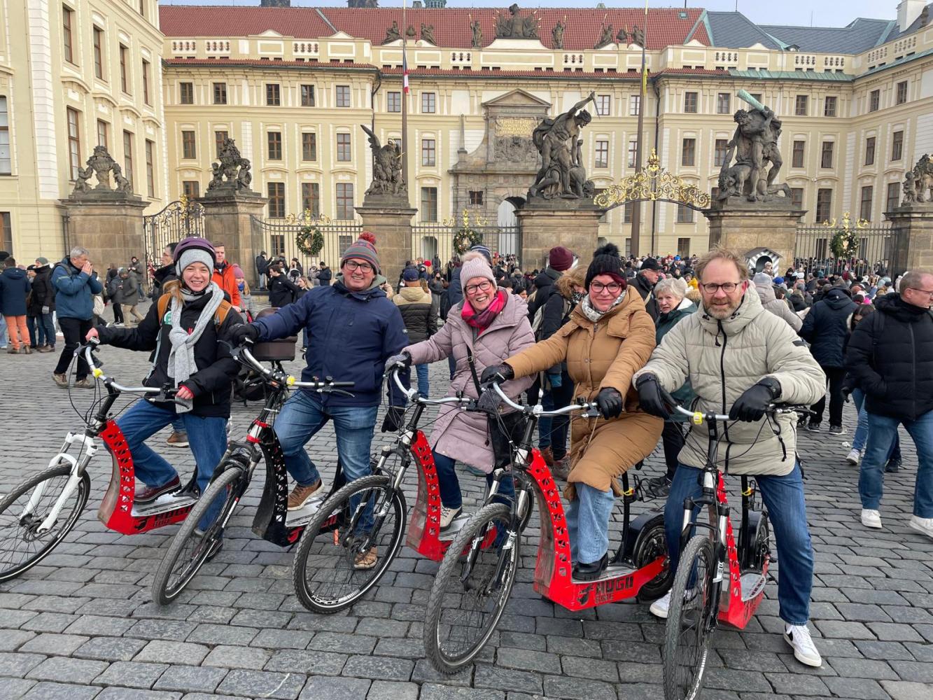 a group of people on a bicycle in front of a building