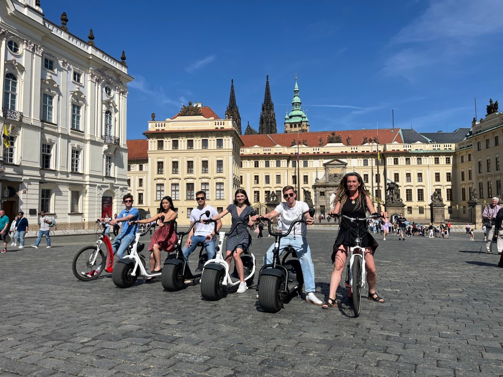 Group of people on segways in a historic plaza with large buildings in the background.